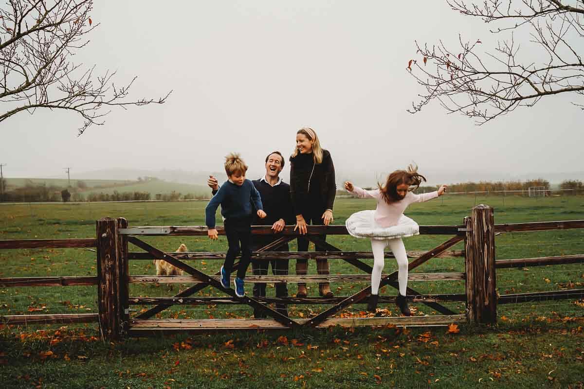 a marlborough family playing around on a gate for a photographer