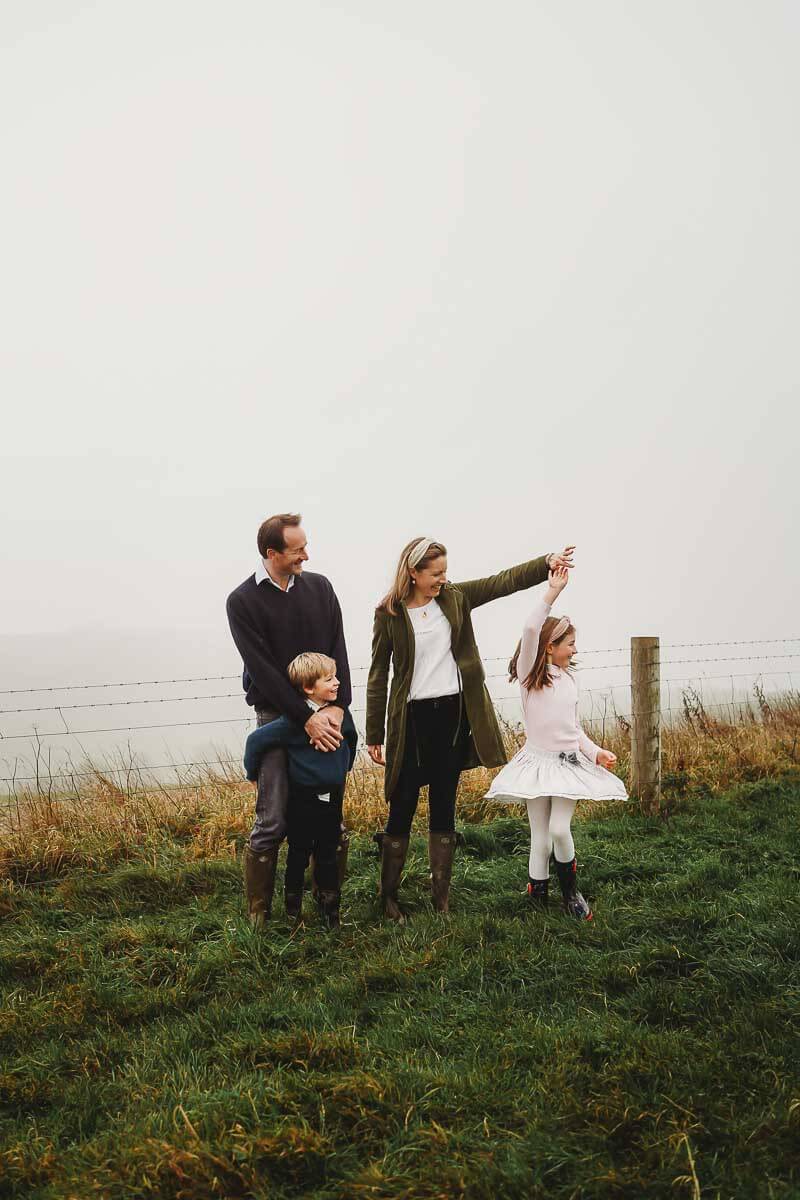 a photo for a photographer in Marlborough showing a family stood watching their daughter twirl around 