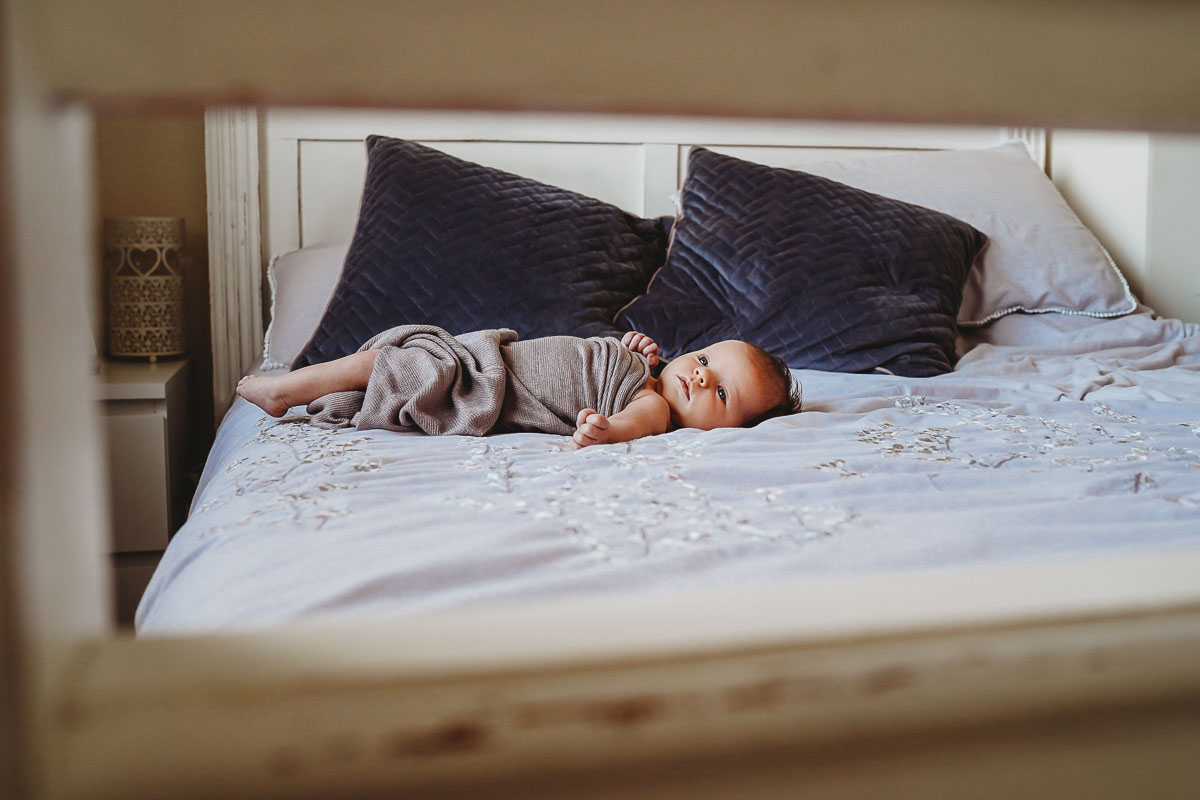 a photo of a baby led on a bed during a newborn lifestyle photoshoot in newbury