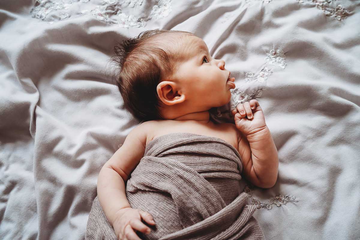 newborn baby sticking her tongue out during a lifestyle photoshoot in Newbury