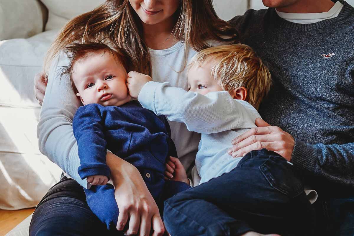 a little boy stroking his baby brothers cheek for a newbury photographer