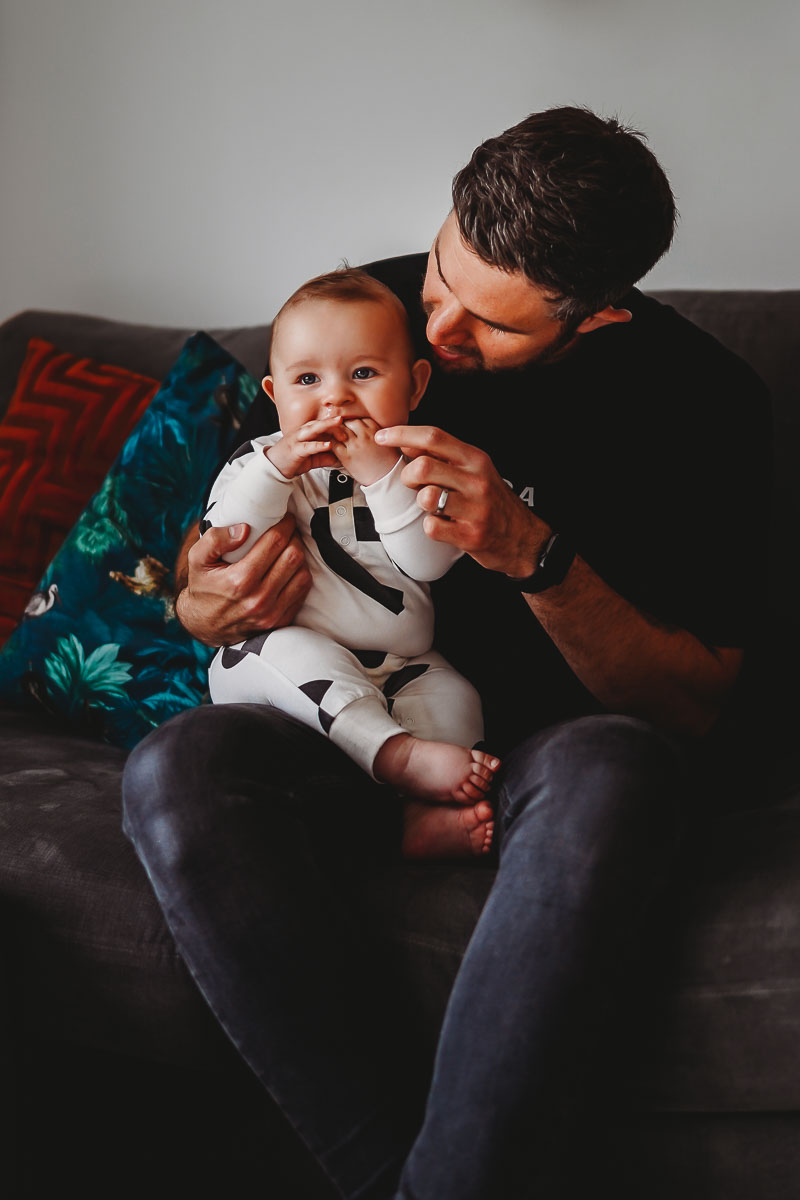 Newborn playing with his dad during an in-home photography session