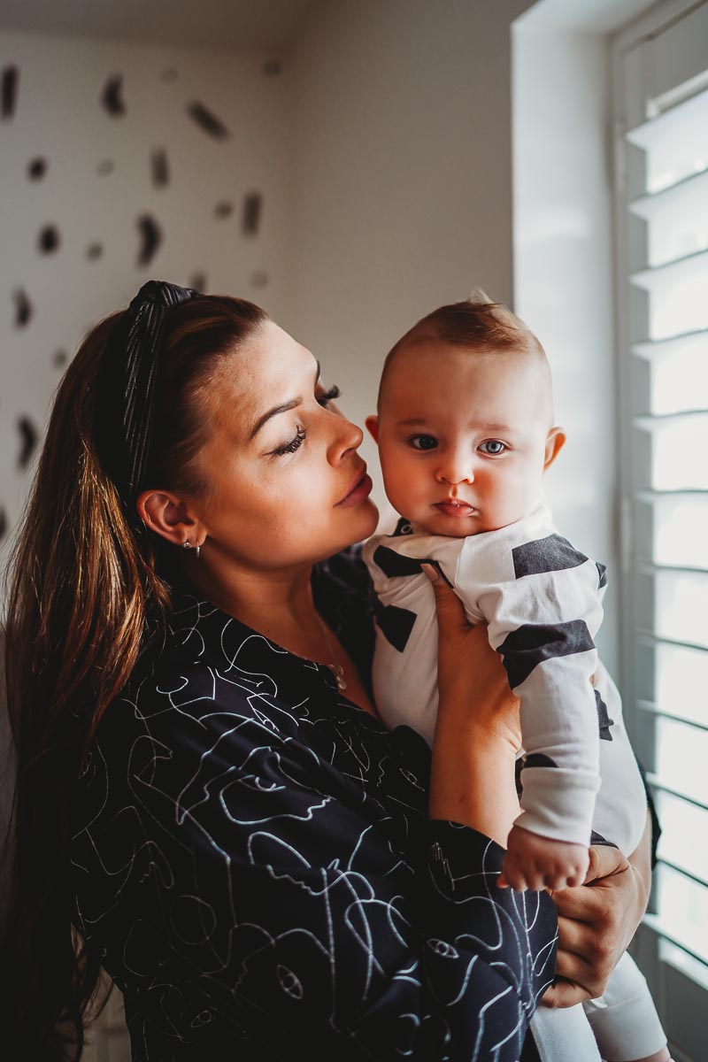 Mum cuddling her newborn baby on an in home photoshoot