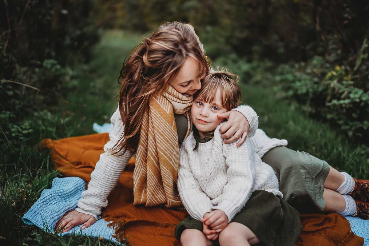 a mother and daughter sat down cuddling for an oxford family photographer