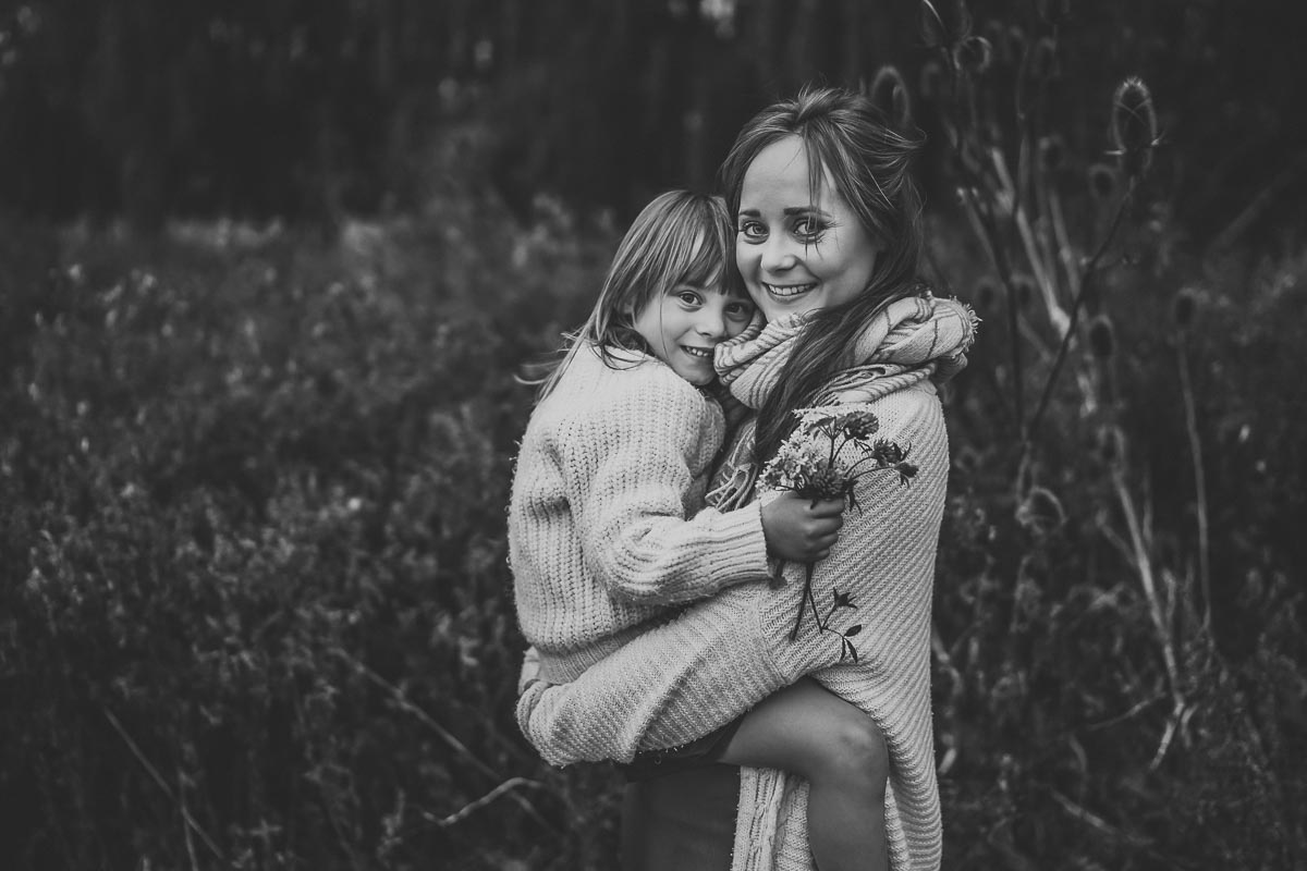 black & white image of a mum cuddling her daughter for their family photographer in oxford