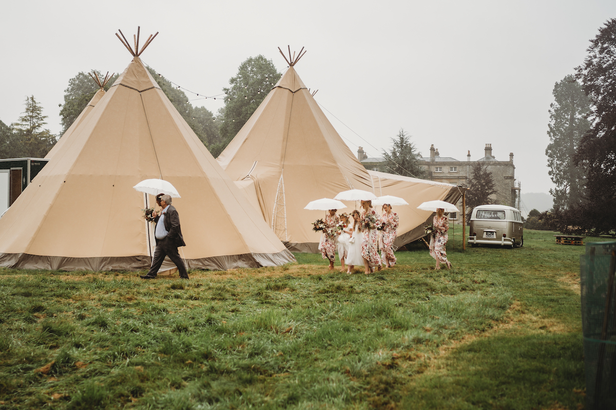 a oxford wedding photographers photo of a bridal party walking to the ceremony in the rain 