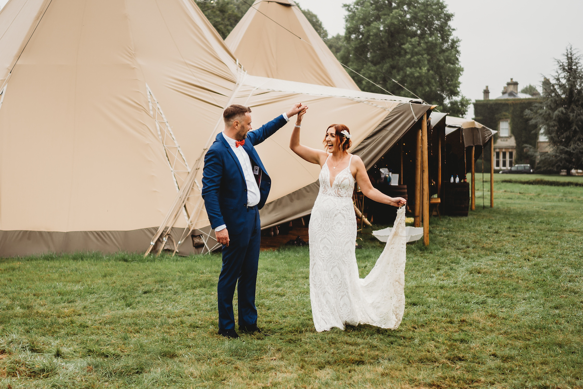 bride & groom dancing in front of their wedding tipis in Oxford