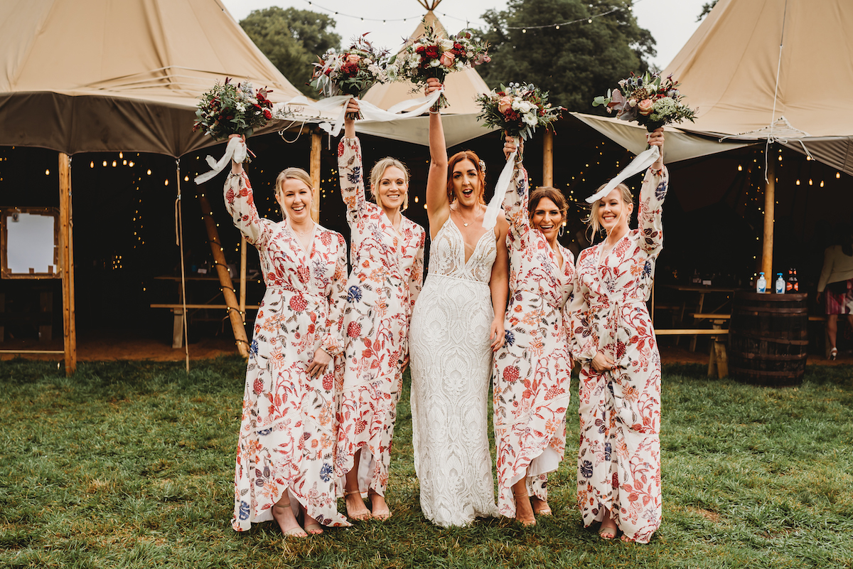 a bride and her bridesmaids cheering with their bouquets