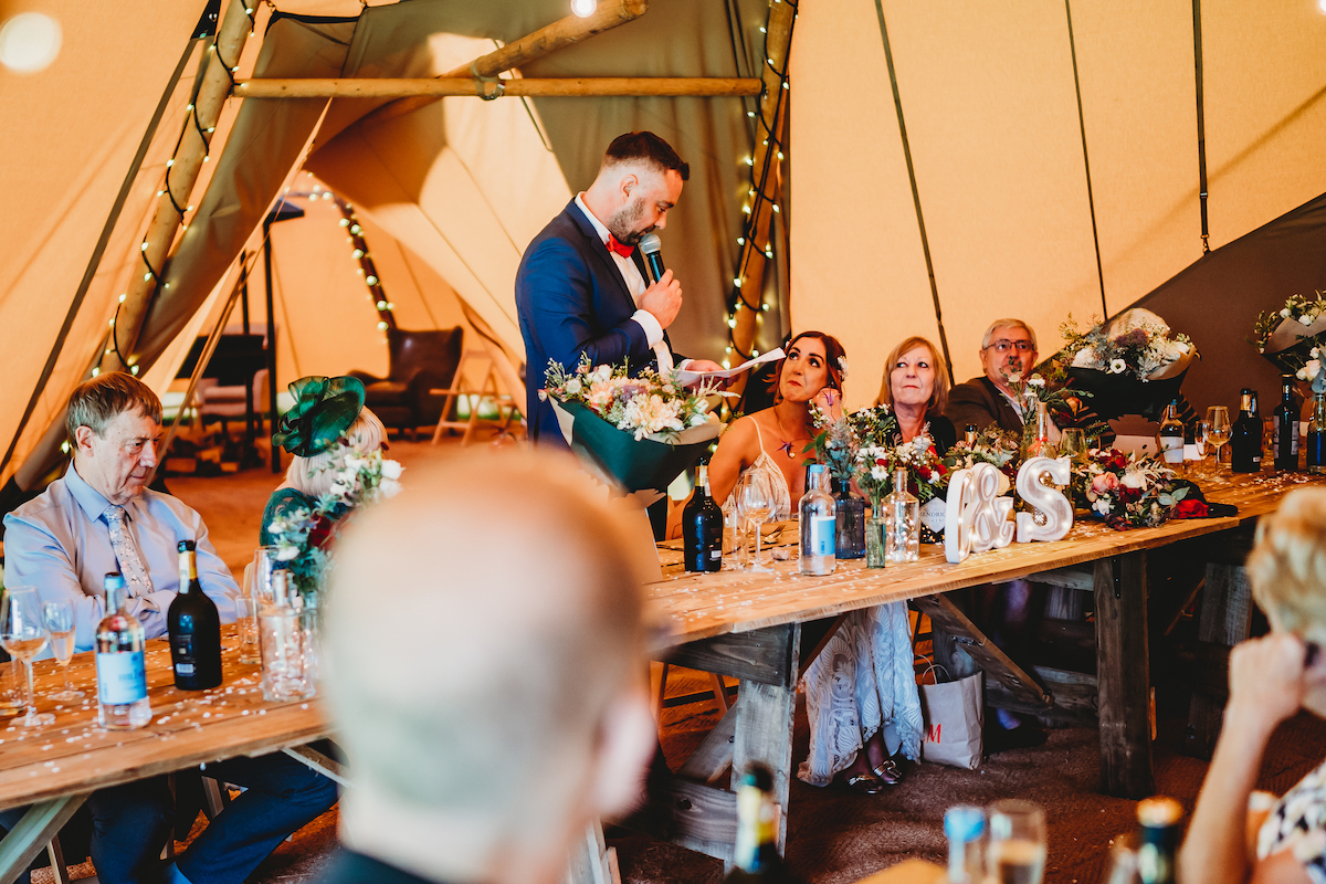 an emotional bride during her husbands speech at a wedding