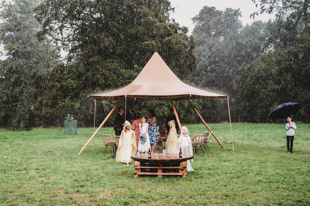 wedding guests wearing ponchos in the rain