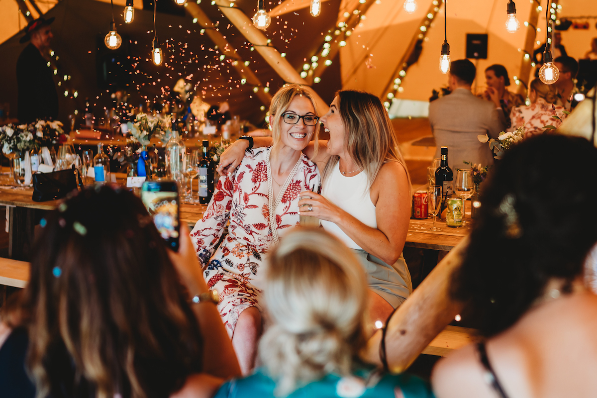 a photo of wedding guests laughing together taken by a newbury wedding photographer