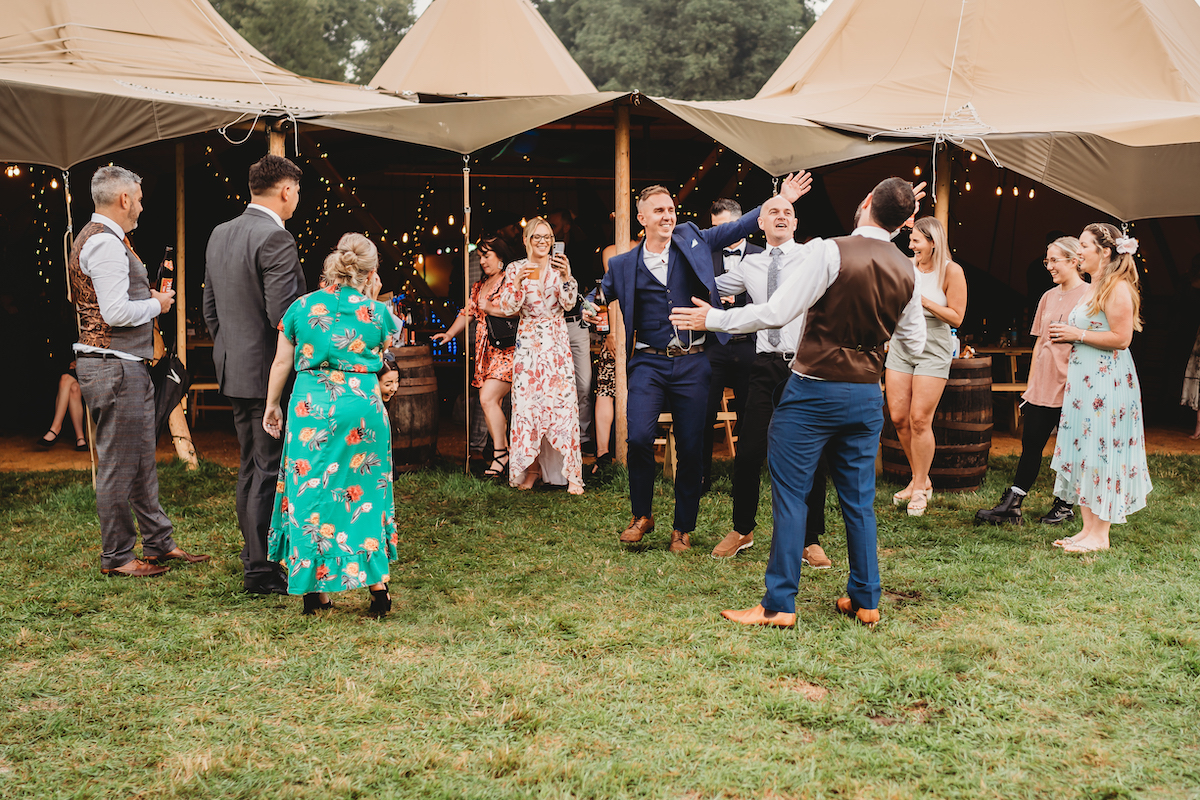 wedding guests dancing outside the tipis