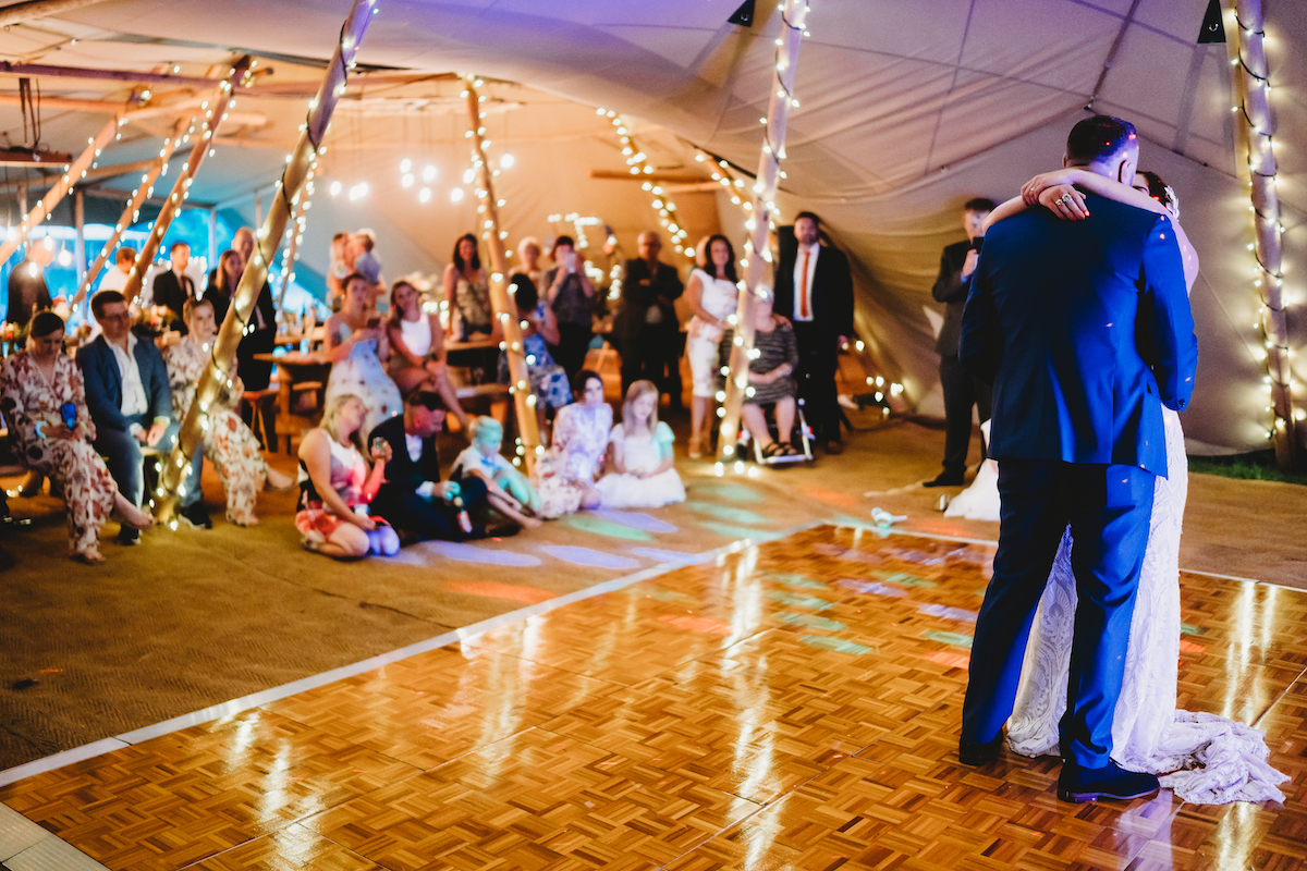 a bride and groom dancing in front of their wedding guests