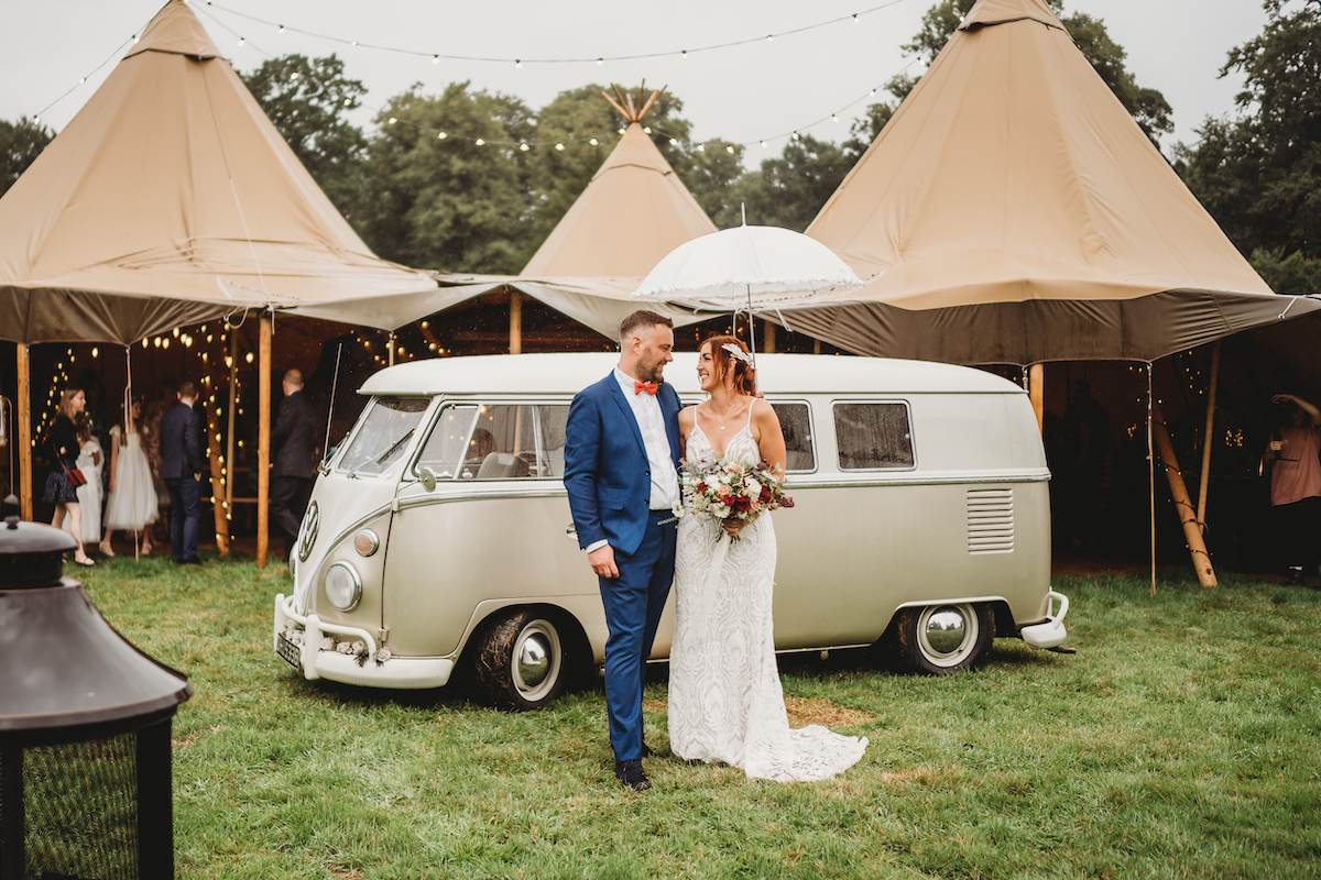 bride & groom pose in front of a vw van for their wedding