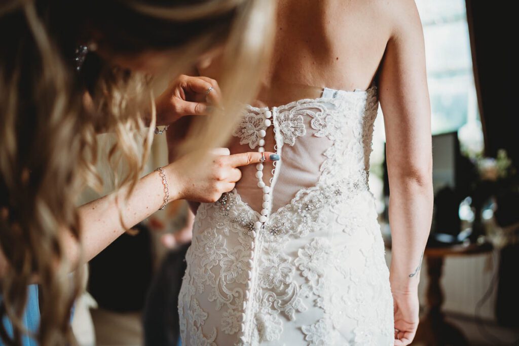 bride getting into her dress from Sofi Designs Bridal