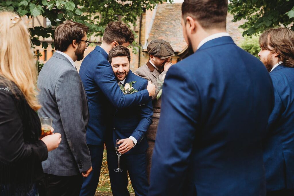 best man hugging the groom at a Barn wedding venues in Berkshire 