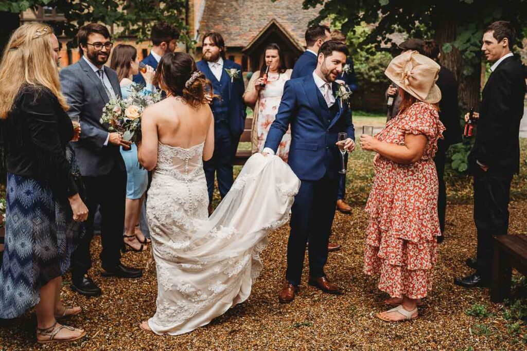 groom holding his brides dress at a Barn wedding venues in Berkshire 