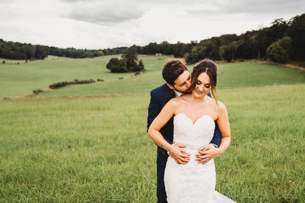 bride and groom cuddling for a photo at a wedding at a Barn wedding venue 