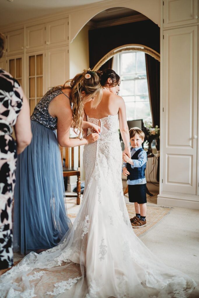 bride getting into her dress from Sofi Designs Bridal 