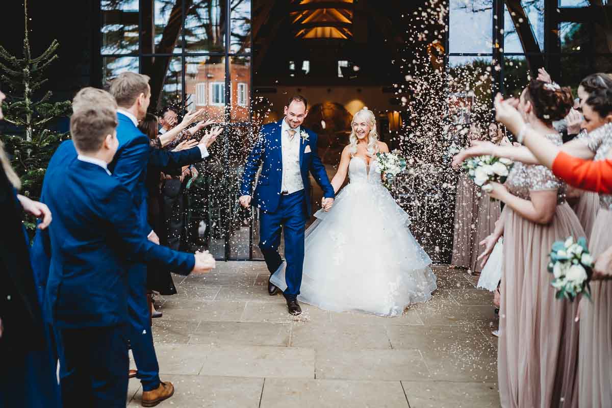 a confetti line throwing confetti at a newly married couple during a christmas wedding in newbury