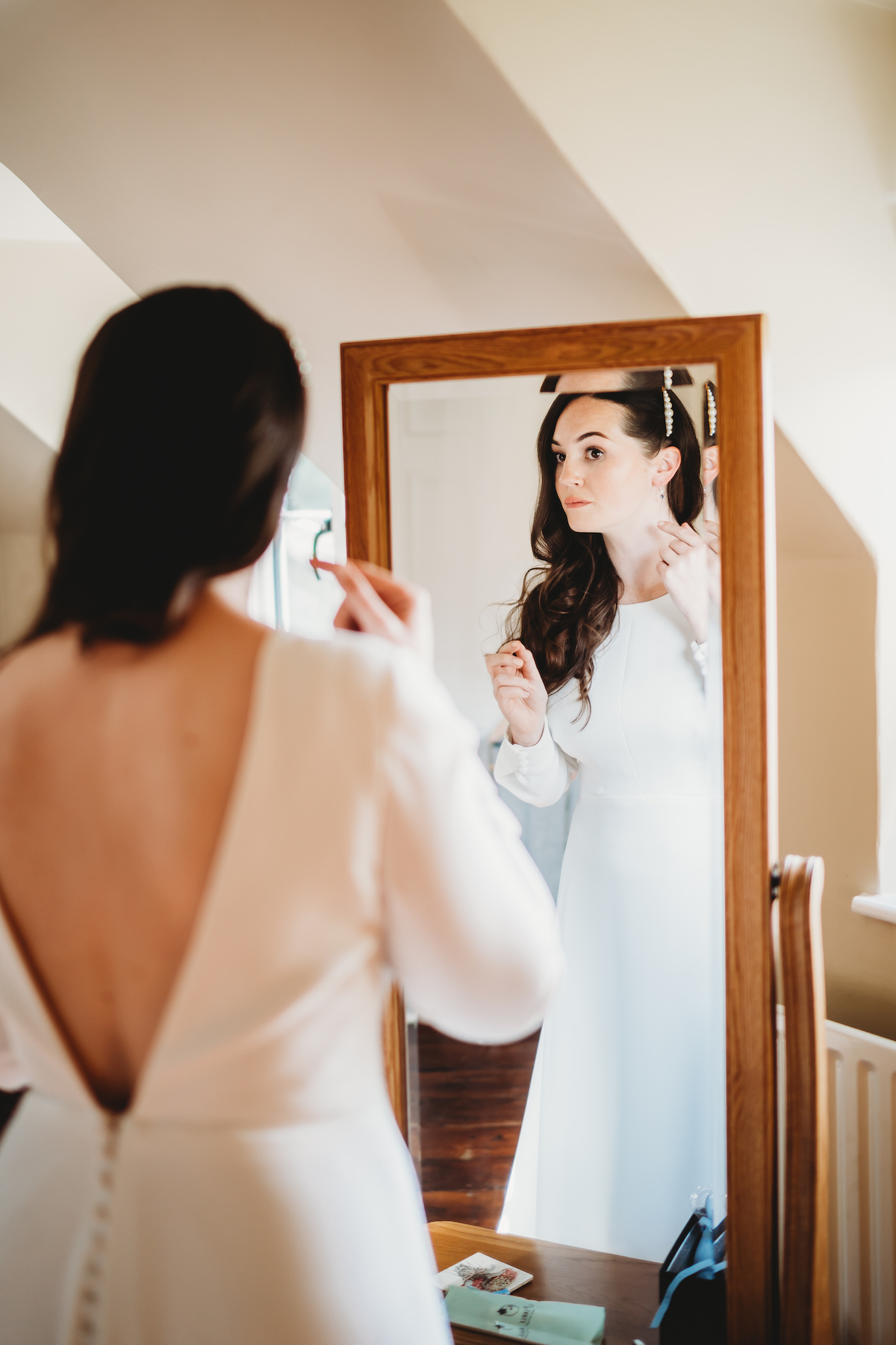 a brides make up touch ups as she looks in the mirror