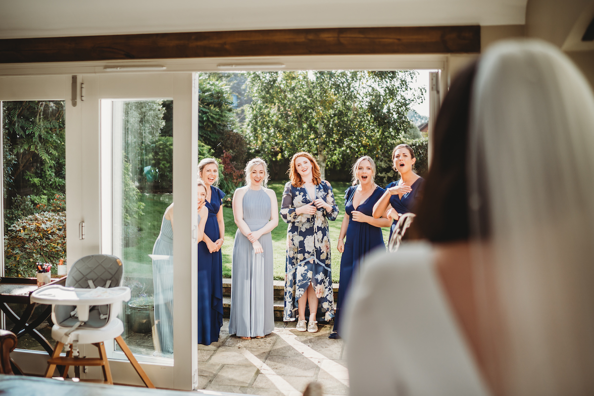 bridesmaids reaction to their bride entering the room taken by a berkshire wedding photographer