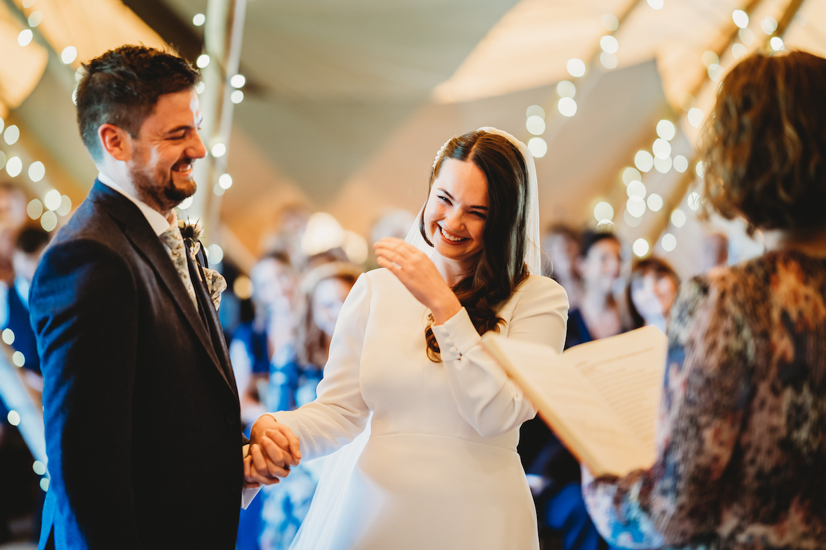 a bride and groom laughing mid wedding ceremony