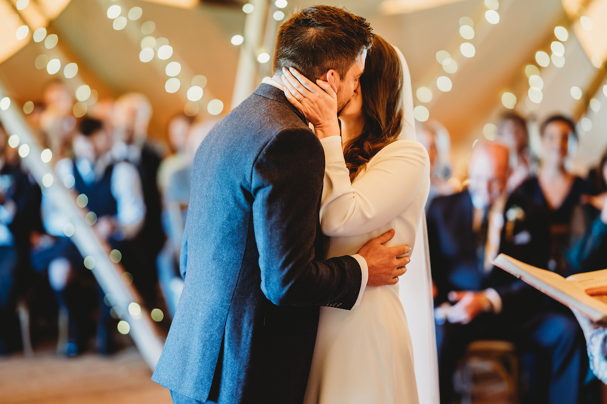 bride and grooms first kiss at Forest edge tipis