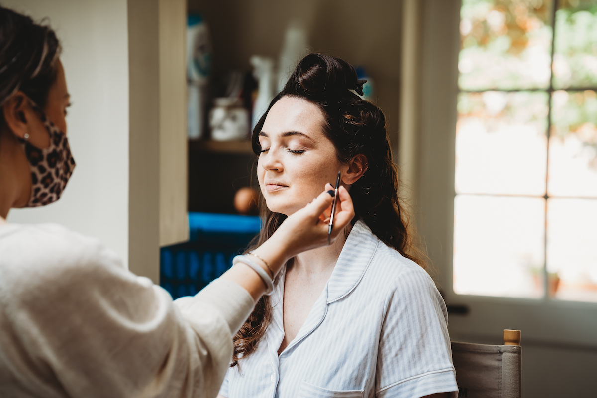 a bride having her make up done before her wedding in Newbury