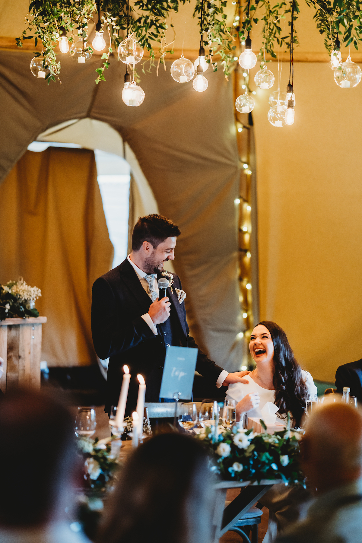 bride laughing at her new husband during their speech 