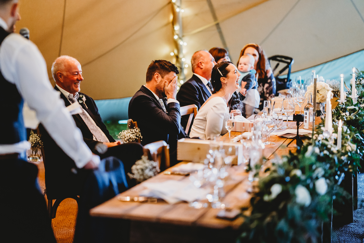 an embarrassed bride and groom during speeches during a newbury wedding