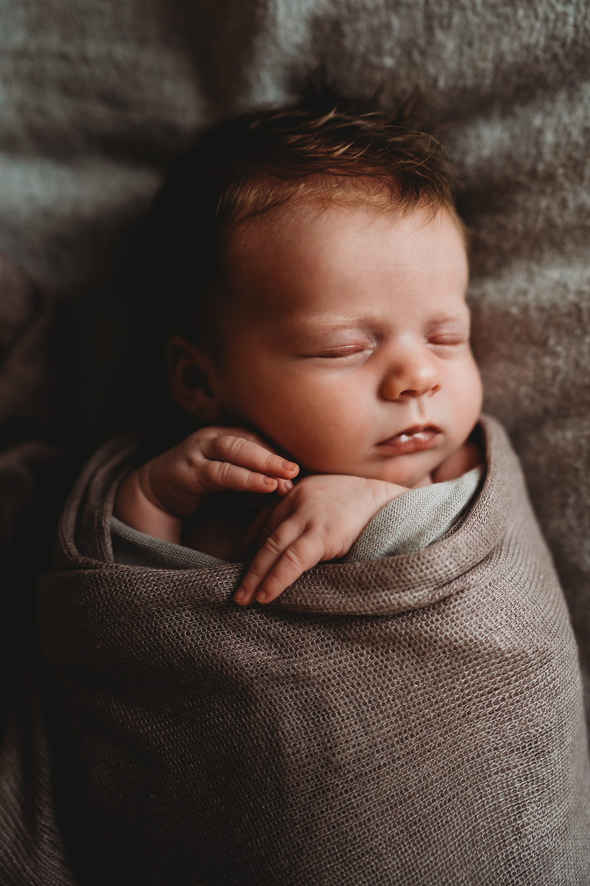 a sleeping baby snuggled up in a blanket for a baby photographer in newbury