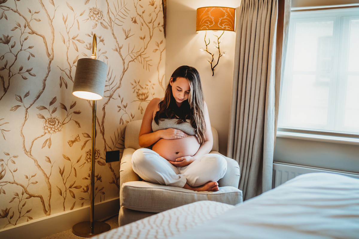 a pregnant lady sat holding her bump for a Berkshire pregnancy photography session