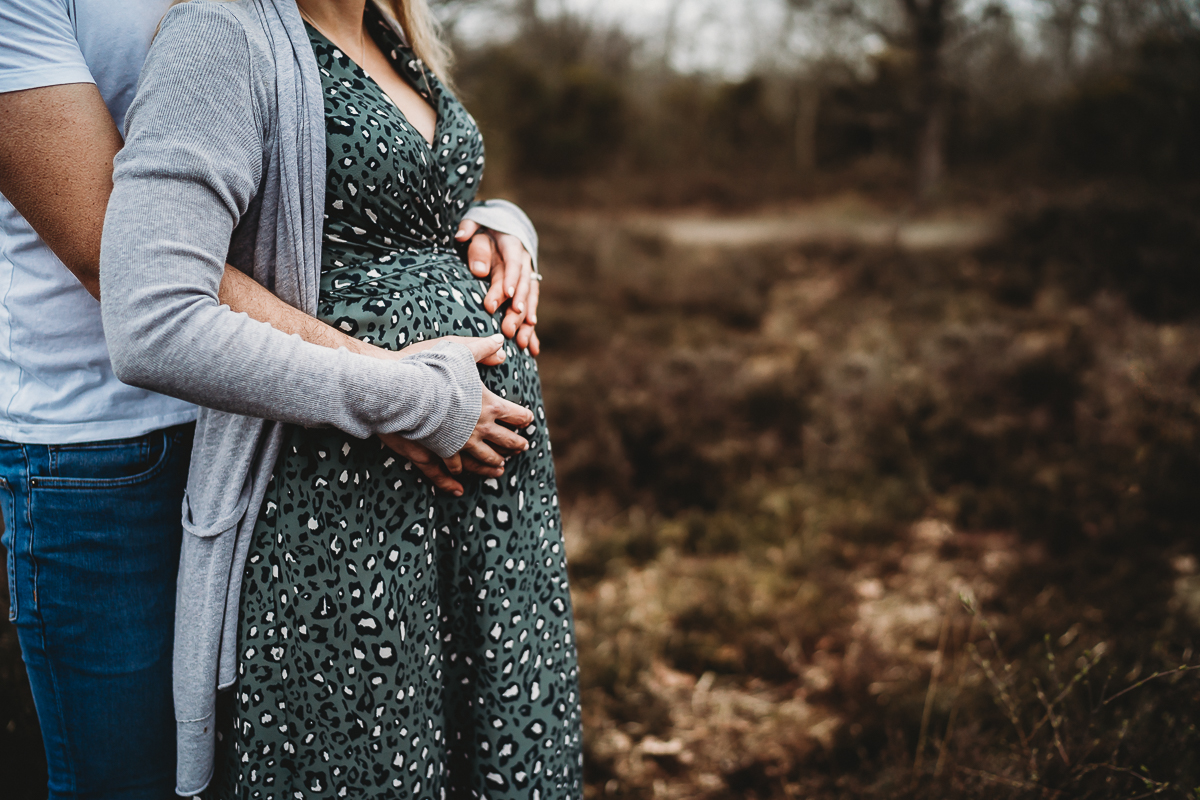 a husband cuddling his wife and her baby bump