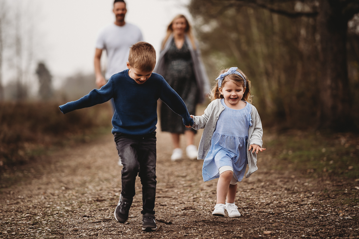 children running along a woodland path 