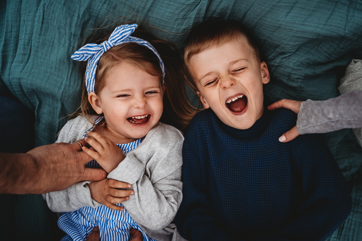 children giggling whilst being tickled for a berkshire family photographer