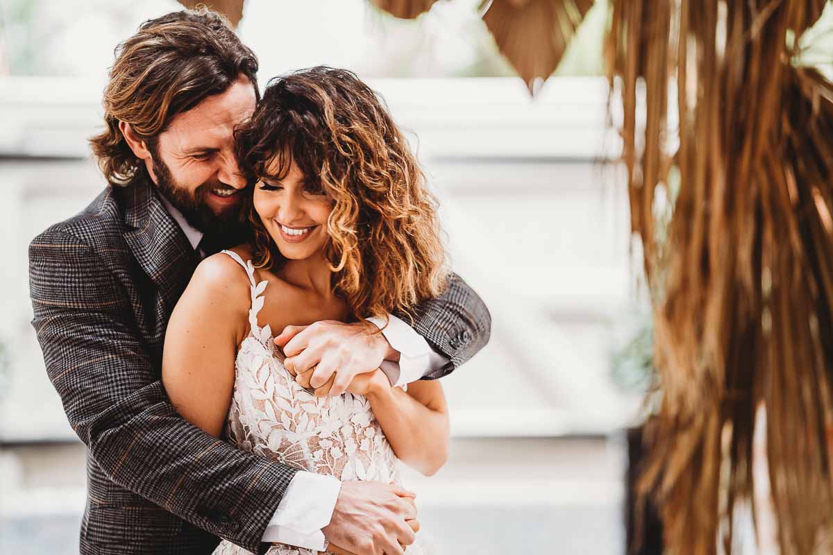 a bride and groom hugging and laughing at a top cotswolds wedding venues