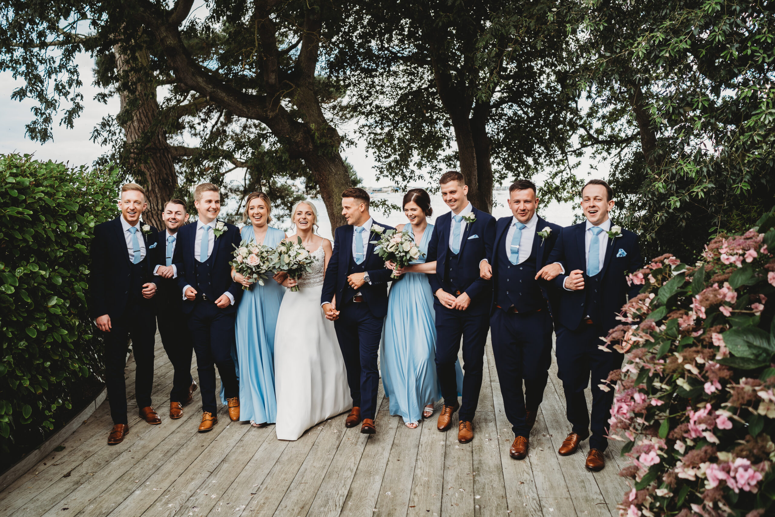 a full wedding party walking towards the camera for a relaxed wedding photographer