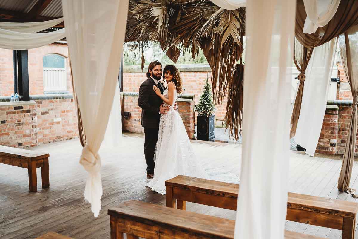 a bride and groom cuddling after their ceremony