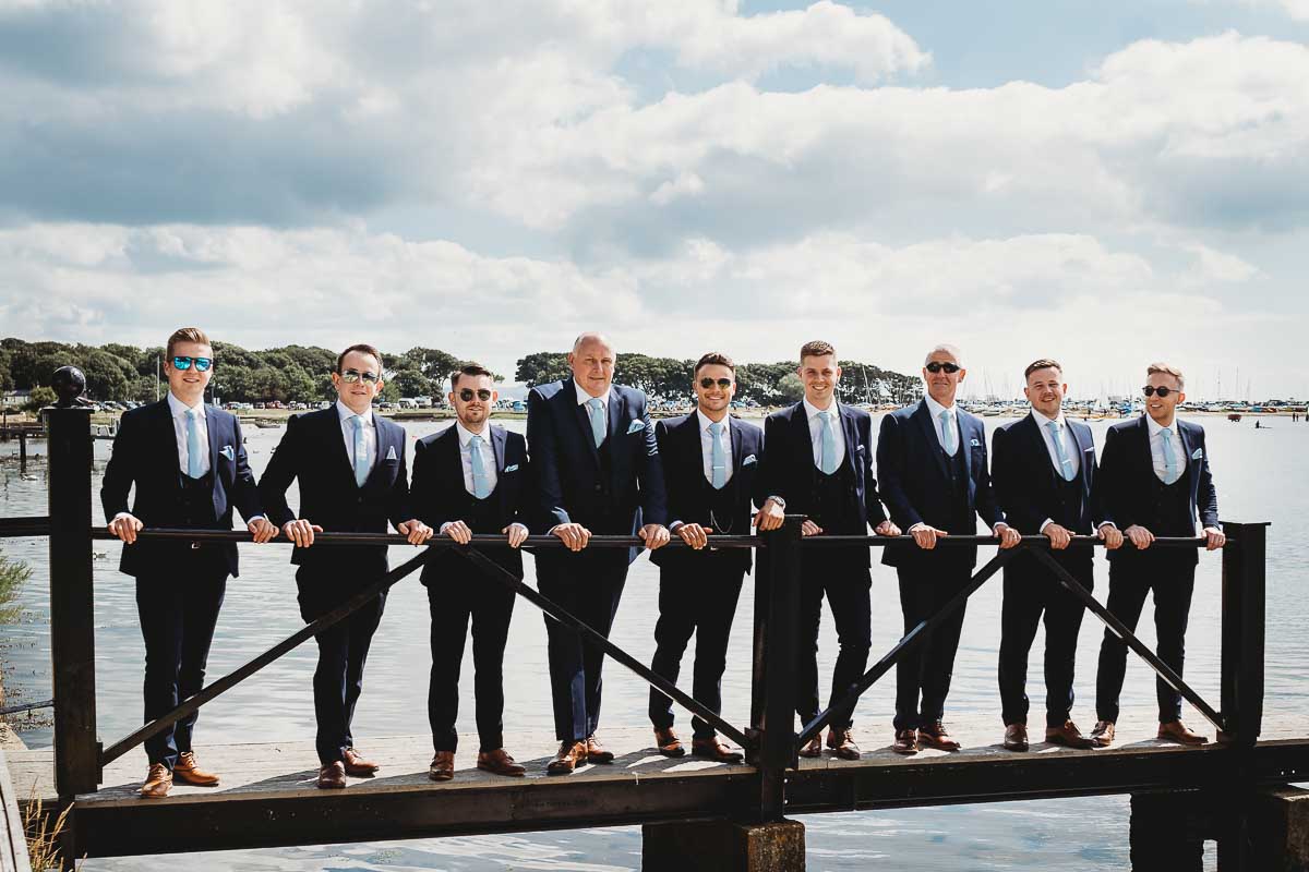 a groomsmen party lining up for a photo with shades on for group wedding photos