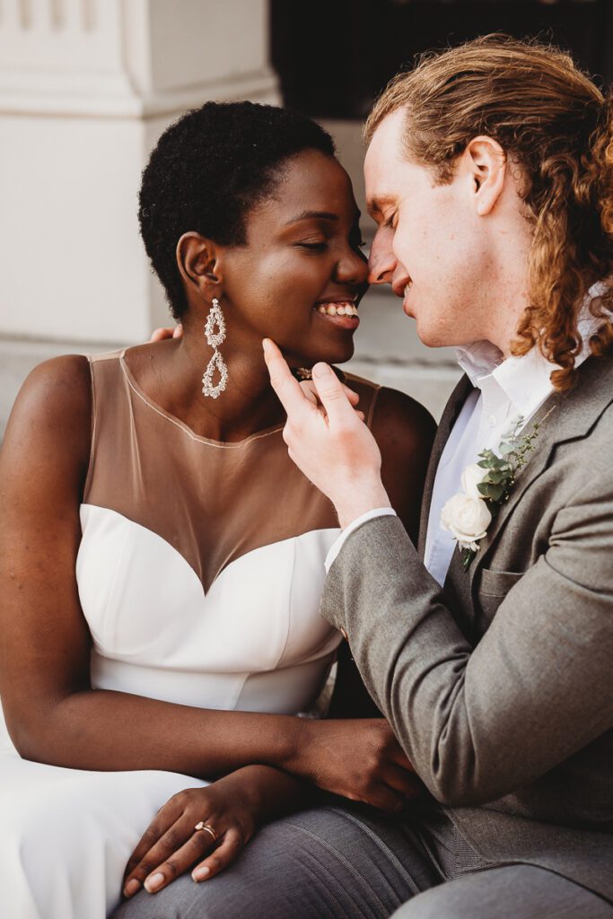 a groom stroking his new wifes face after their city elopement