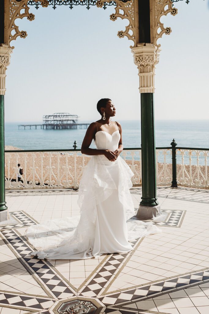 a bride stood on Brighton Pier after her city elopement, looking out to sea