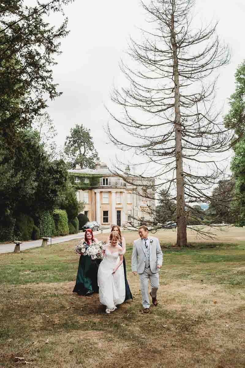 a bridal party walking and chatting before their Forest Edge tipi wedding