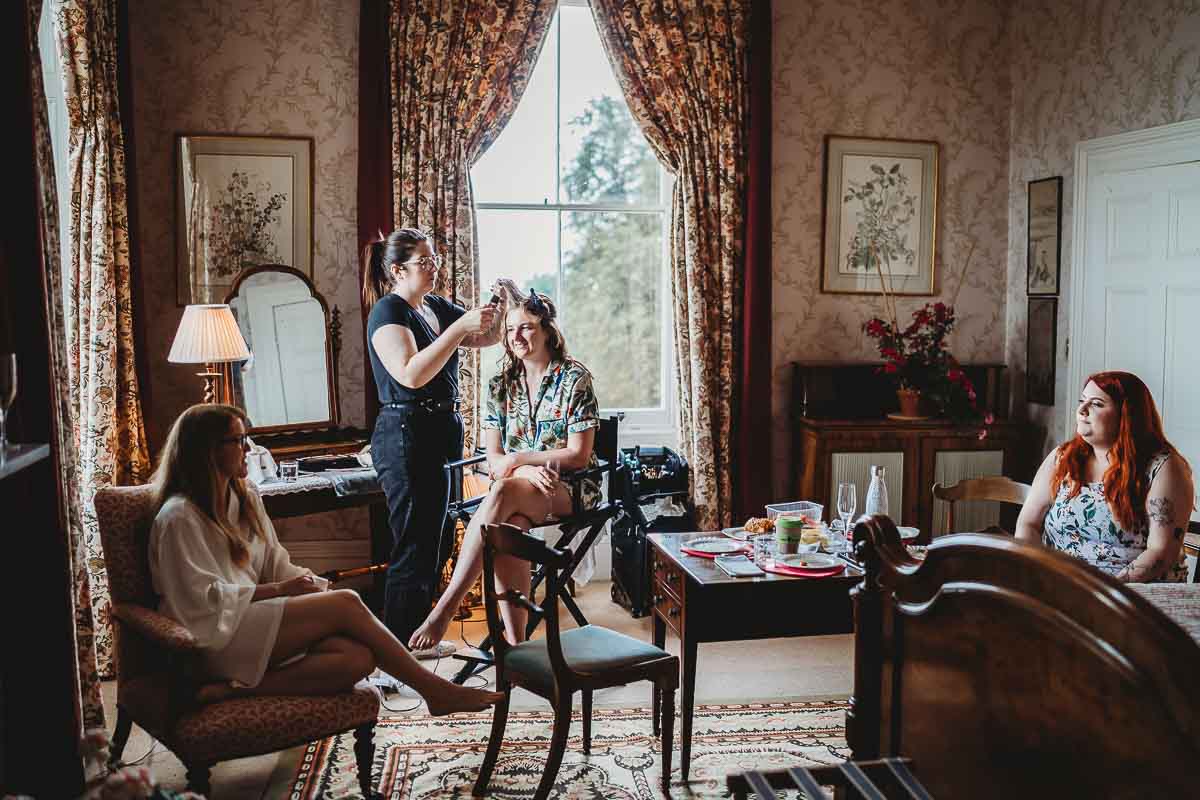 a bridesmaid having her hair done ahead of a oxfordshire tipi wedding