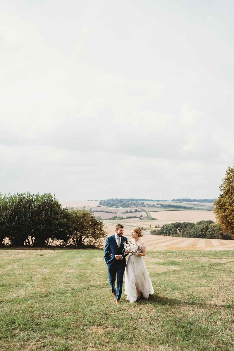 a bride and groom walking and chatting for their Oxfordshire wedding photographer