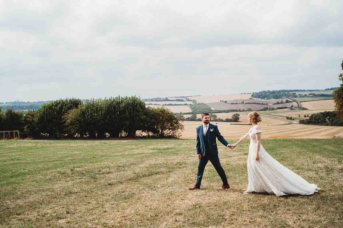 a groom leading his bride after their Woolley Park wedding in Oxfordshire