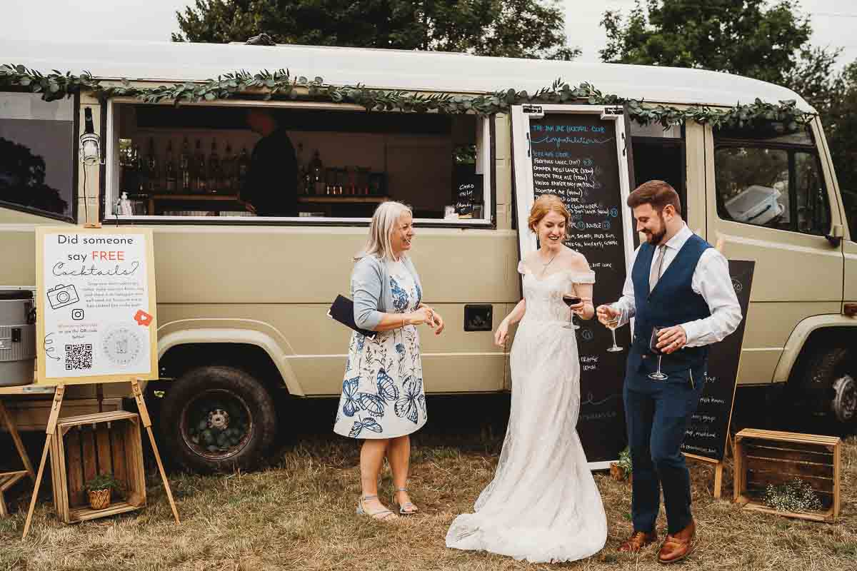 a bride and groom getting a drink from a drinks truck at their Woolley Park Estate wedding