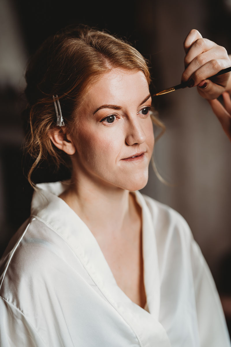 a bride having her make up done before her wedding, taken by a berkshire wedding photographer 