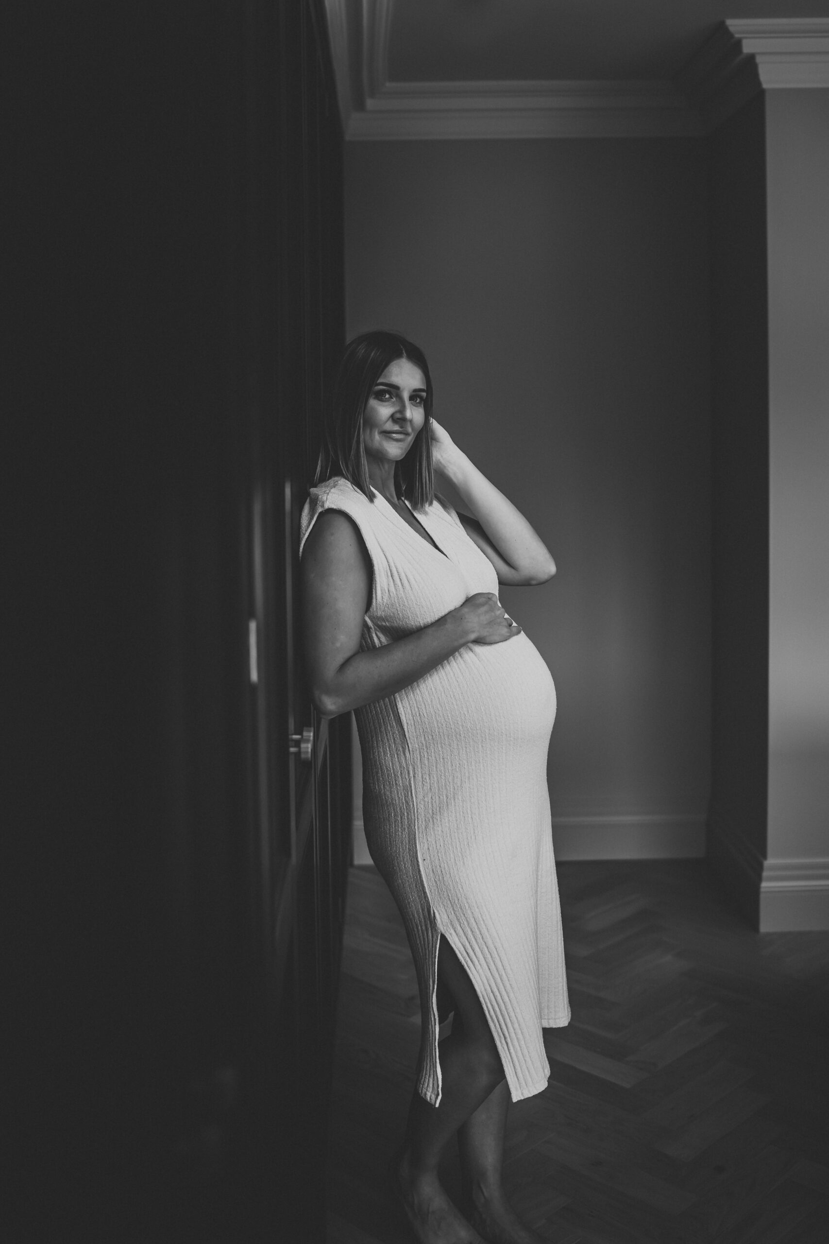 a mother-to-be leaning against a wall for her maternity photo shoot