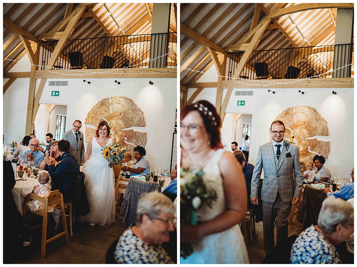 a bride and groom entering the wedding breakfast for getting married at The Post barn Newbury